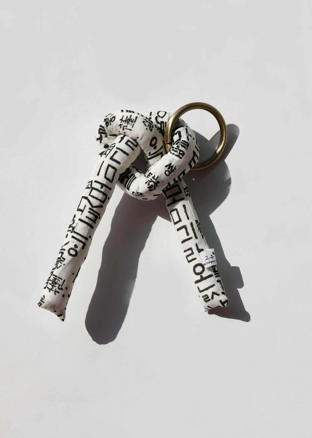 Korean artisan key ring featuring a heart shape and traditional Hunminjeongeum textile design.